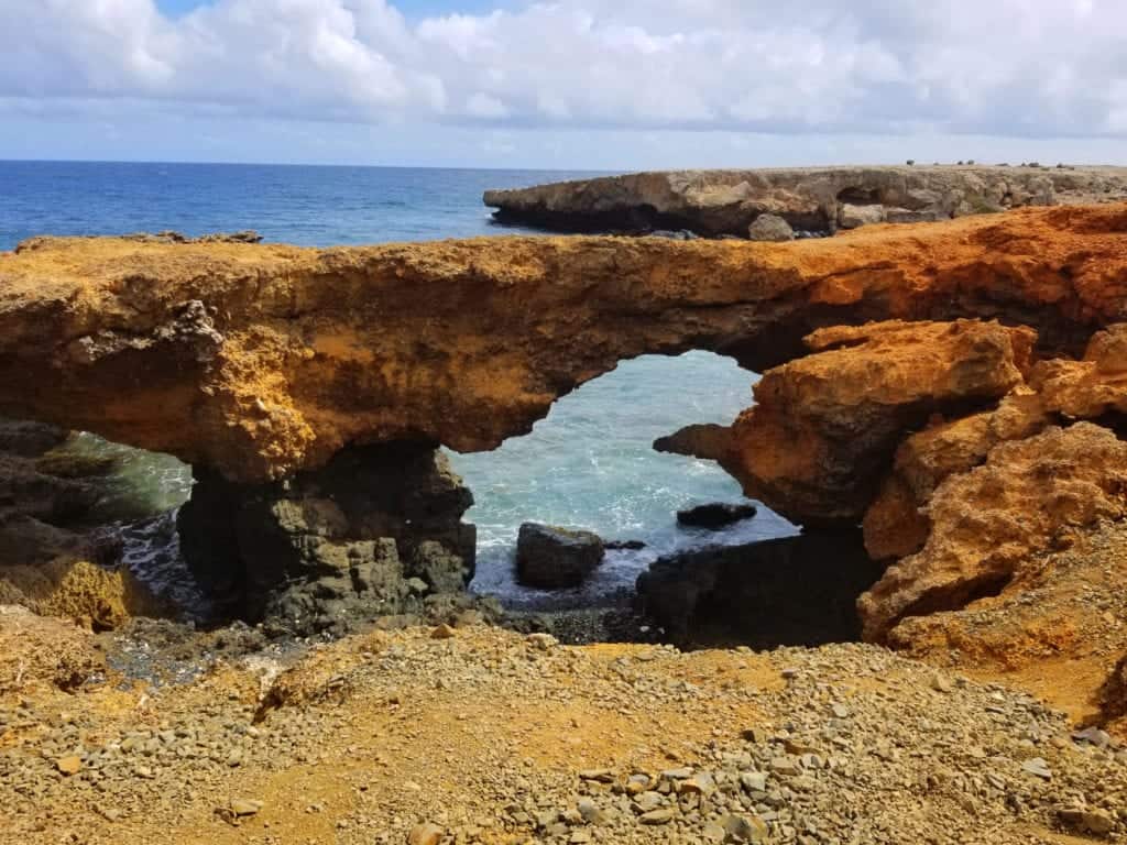 Aruba in One Day: Aruba UTV Tour Review (Aruba ATV Review) 8 A natural bridge extending into the ocean, with waves crashing against its base.