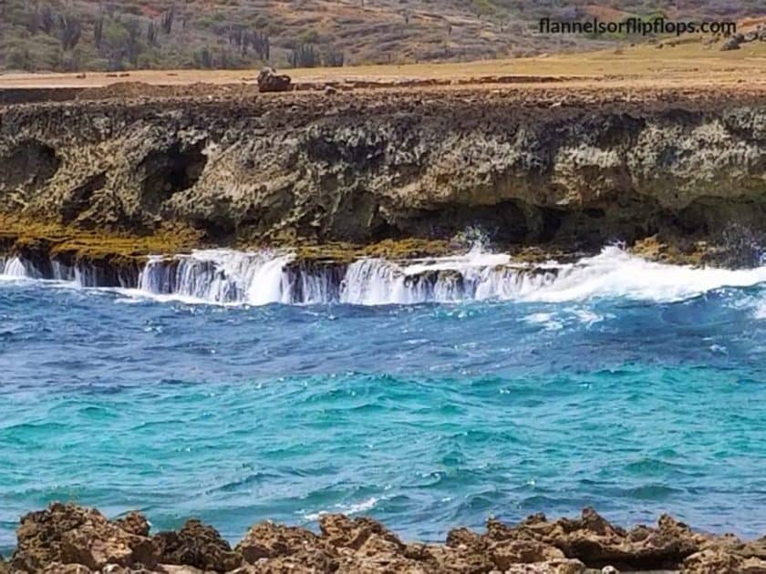 Aruba Blue water agains rocky shore.