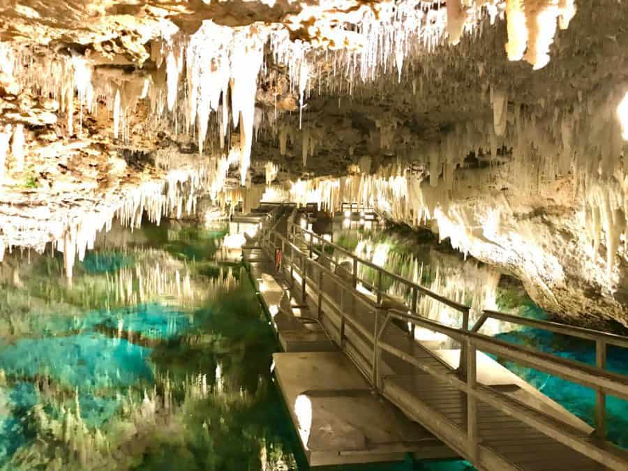 Stunning rock formations inside the Bermuda Caves and crystal clear water reflecting off cave walls.