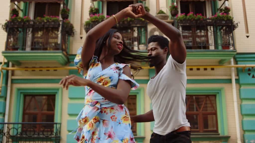 African american couple moving with rhythm outdoors. Happy african professional dancers curling in latino dance in city.