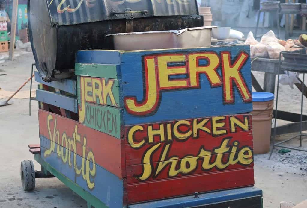 Colorful Jerk Chicken cart decorated with traditional Jamaican patterns serving mouth-watering jerk chicken.