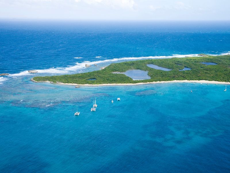 Aerial view of Icacos Island, displaying its beautiful sandy beaches and clear turquoise waters, surrounded by a lush, natural landscape.