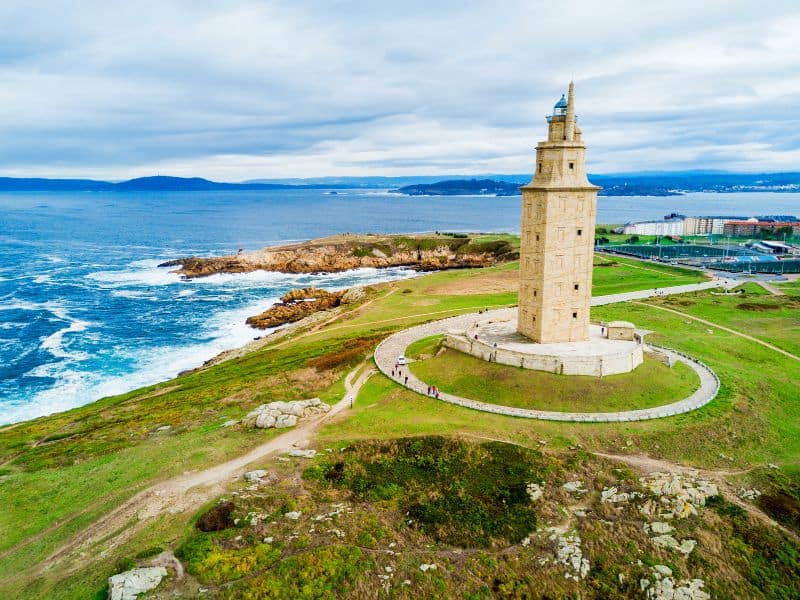 Exploring Cruise Ports in Spain: All you need to Know 11 Tower of Hercules surrounded by green grass and the sea in the background