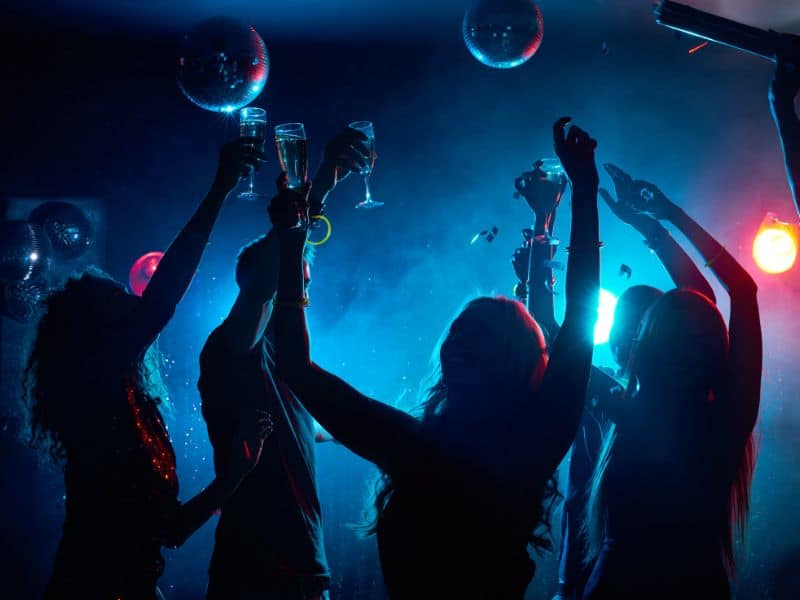 People dancing in a club holding champagne