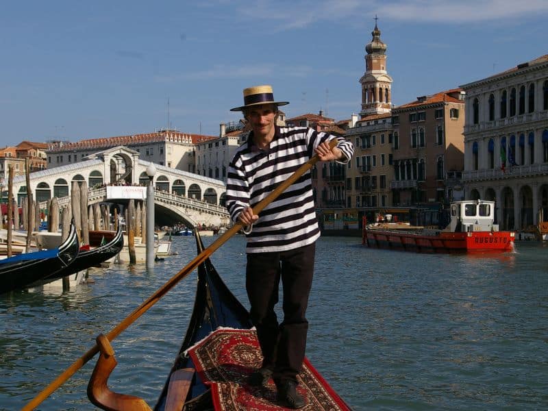Venice Italy Cruise Port Guide: Everything You Need to Know 5 Man in black and white striped shirt paddles a gondola in venice