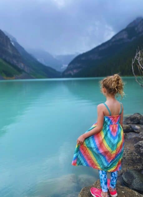 The tranquil Lakeshore of Lake Louise, encompassed by the awe-inspiring Rocky Mountains, with crystal-clear turquoise waters and a backdrop of natural splendor.