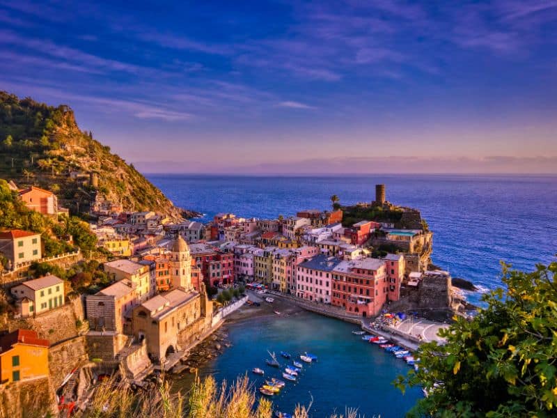 10 Best Livorno Shore Excursions 12 A mesmerizing sunset over Cinque Terre, Italy, highlighting the vibrant colors of the coastal villages nestled amidst cliffs and the sparkling Mediterranean Sea.