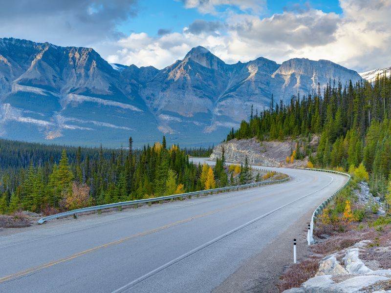A scenic drive along Icefields Parkway in summer, showcasing majestic mountains, glacial lakes, and stunning vistas of the Canadian Rockies.