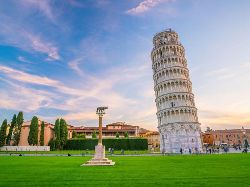 10 Best Livorno Shore Excursions 8 The serene view of Pisa, Italy, in the afternoon, showcasing the iconic Leaning Tower of Pisa and its surrounding framed by a clear blue sky and bathed in the gentle sunlight, creating a timeless and captivating sight.