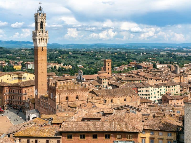 10 Best Livorno Shore Excursions 14 The stunning city of Siena, Italy, showcases its iconic medieval architecture surrounded by charming rooftops and rolling hills, capturing the essence of Siena's timeless allure.