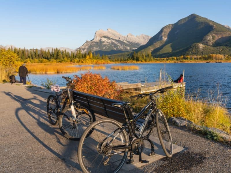 When is the Best Time to Visit Banff, Canada? 10 Capture the essence of fall at Vermilion Lakes with this picturesque scene: a man, two bikes, and nature's vibrant palette.