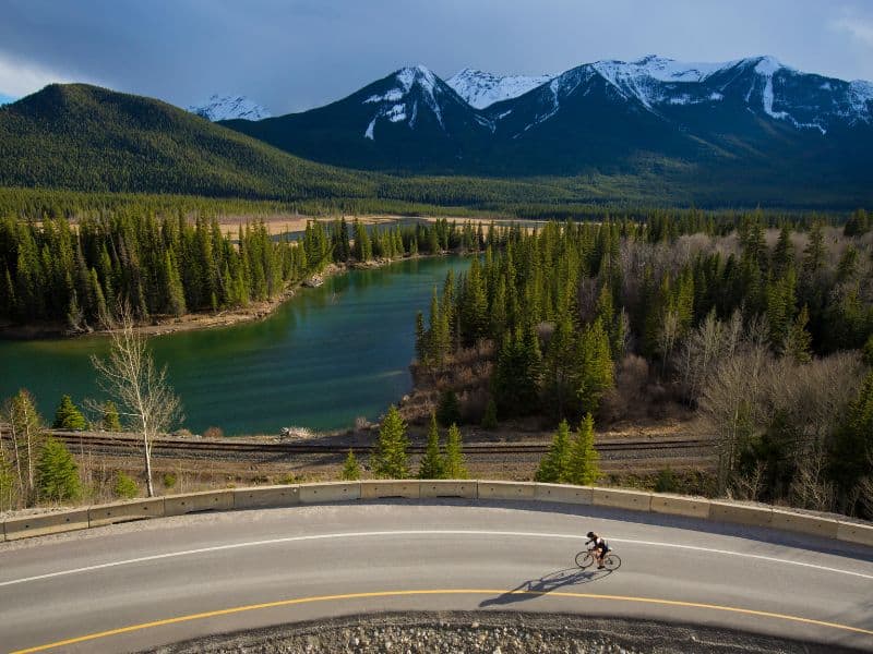 When is the Best Time to Visit Banff, Canada? 8 Capture the essence of freedom and adventure as a man navigates the captivating Bow Valley Parkway on his bike, surrounded by the unspoiled beauty of Banff's wilderness.