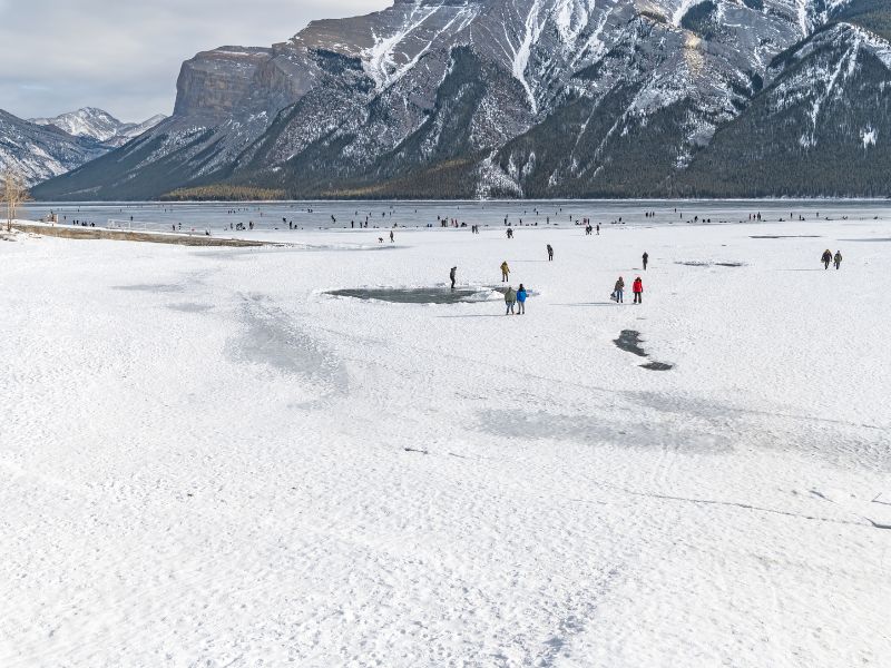 When is the Best Time to Visit Banff, Canada? 16 The joyful spectacle of people ice skating, where laughter and smiles echo across Banff's frozen lakes, as families and friends glide gracefully against the backdrop of the stunning Canadian Rockies.