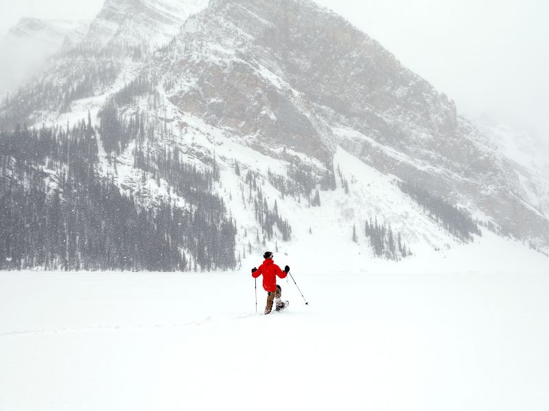 When is the Best Time to Visit Banff, Canada? 15 The tranquility of a man snowshoeing through the pristine wilderness of Banff as he immerses himself in the serene beauty of the Canadian Rockies blanketed in winter's pure, untouched snow.