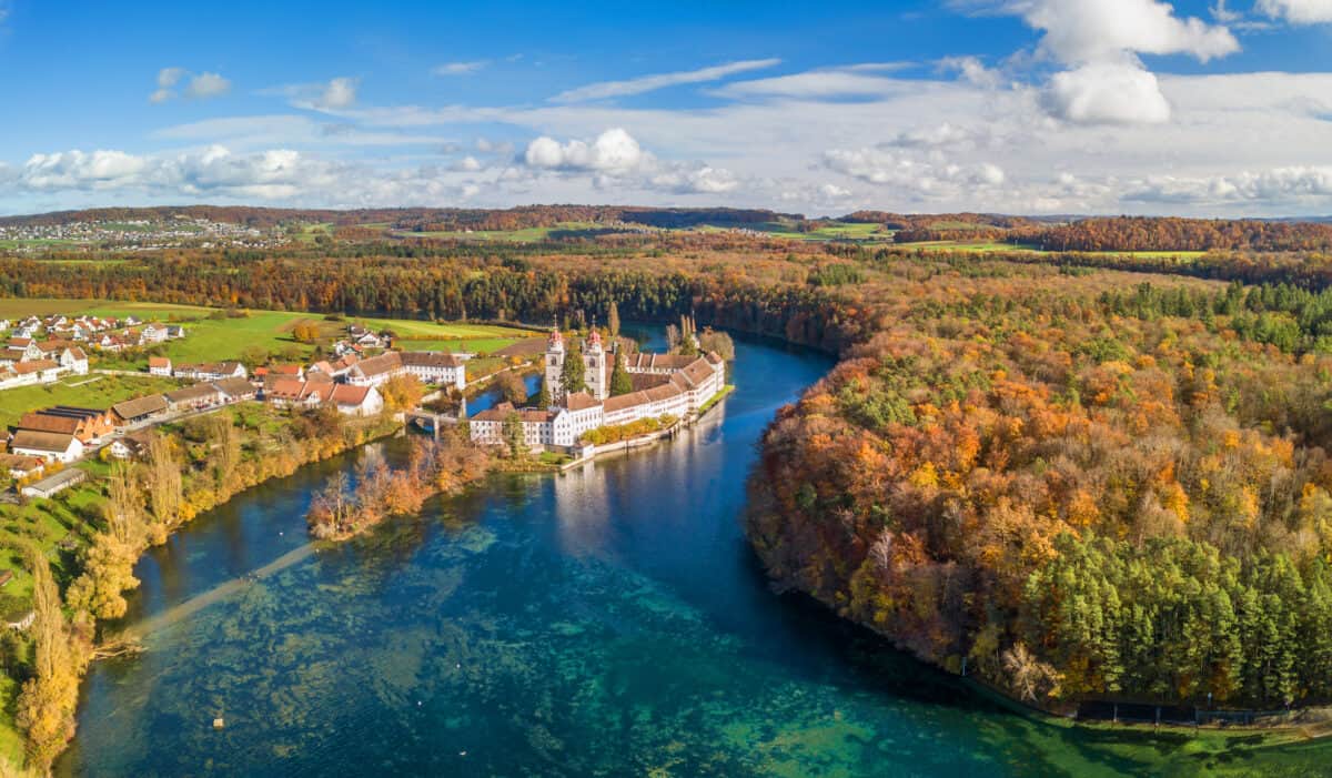 Rheinau, Switzerland - November 11. 2022: Aerial panorama view of the Rheinau Abbey Islet on Rhine river in autumnal splendid colors, Switzerland