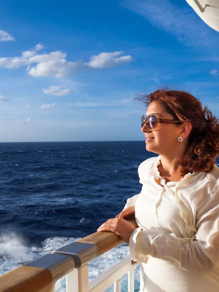 Woman looking over cruise ship
