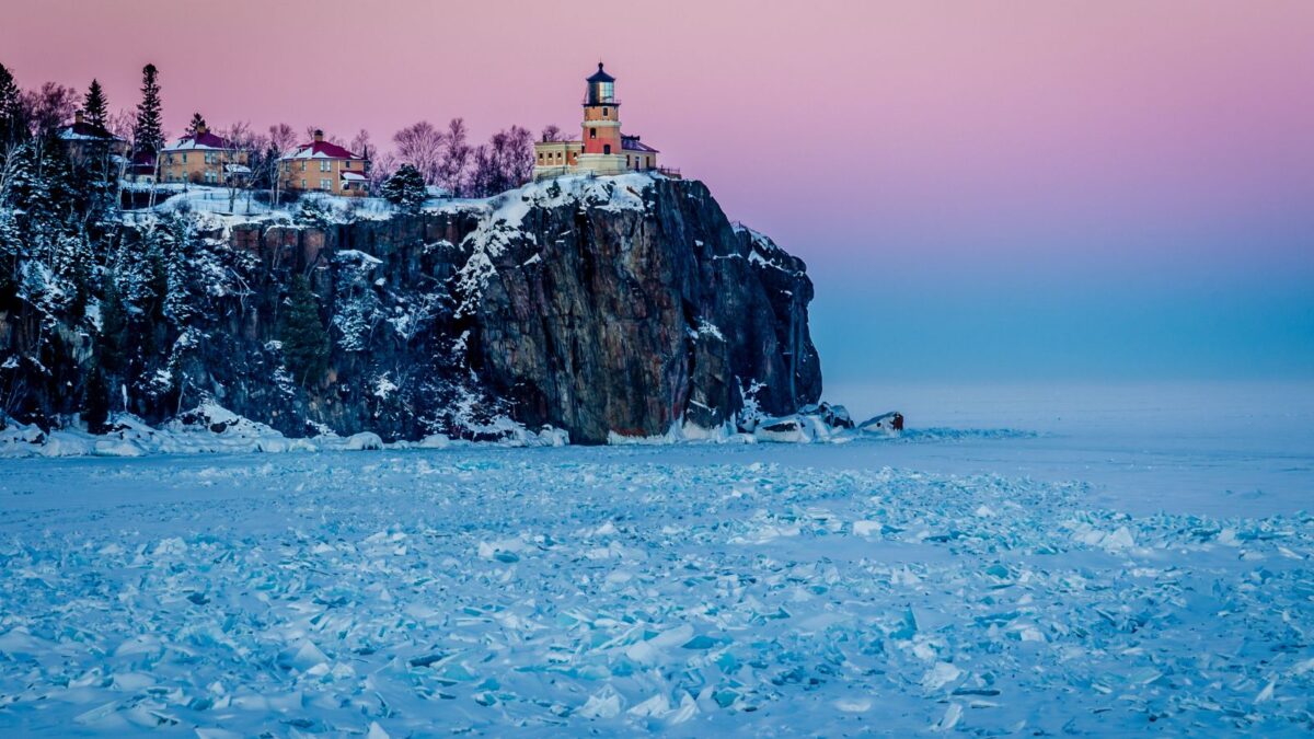 A historic lighthouse on a cliff overlooking a frozen lake under a twilight sky.



A historic lighthouse on a cliff overlooking a frozen lake under a twilight sky.






