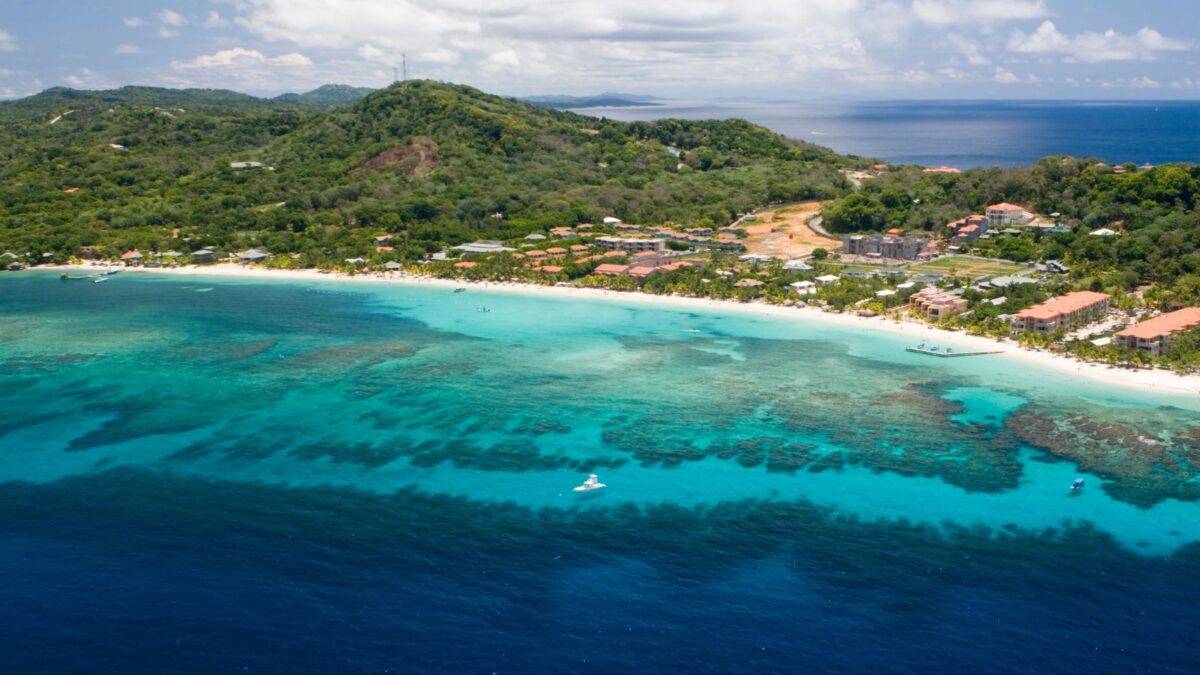 Arial view of the vibrant Roatan Honduras beaches with turquoise waters and lush greenery.