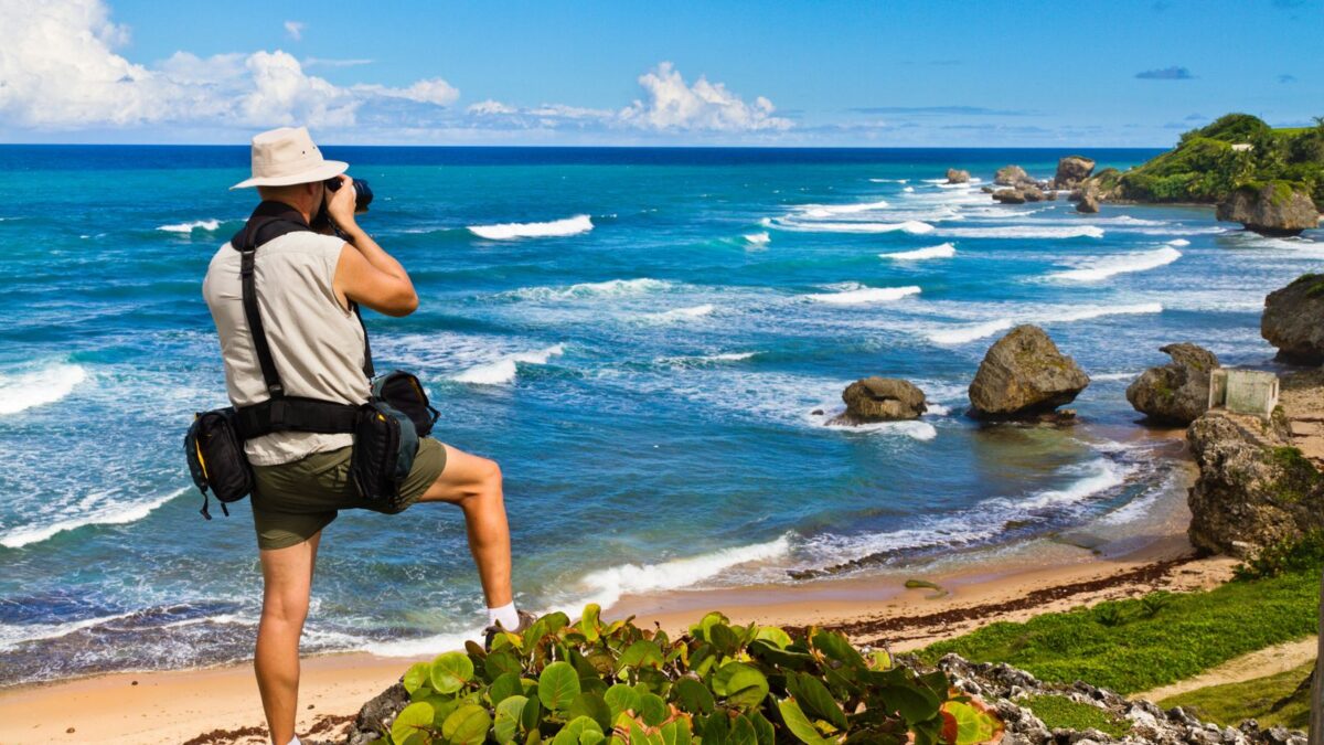 The Best Barbados Beaches Near Cruise Port To Explore 8 Aerial view of Bathsheba Beach in Barbados, highlighting its big rocks, blue waters, and a man taking a picture of this picturesque landscape.