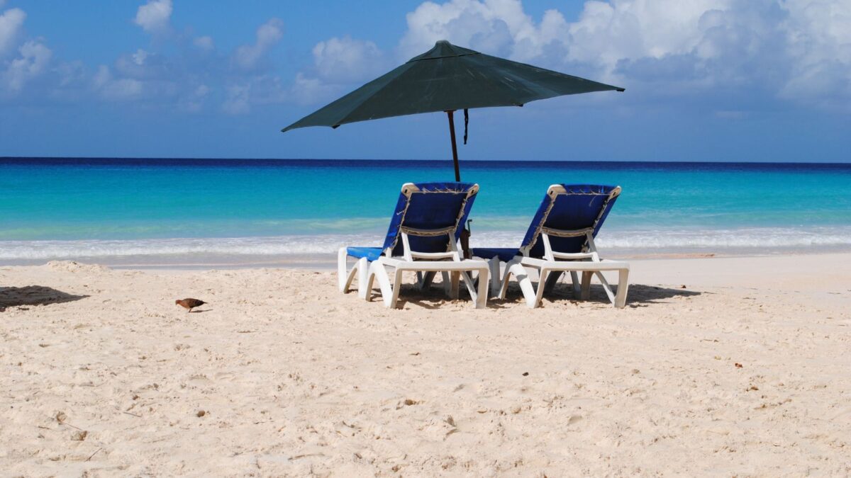 The Best Barbados Beaches Near Cruise Port To Explore 3 Brandons Beach, a tranquil Barbados Beaches near the Cruise Port, featuring beach chairs and umbrellas against a backdrop of clear blue waters and white sand