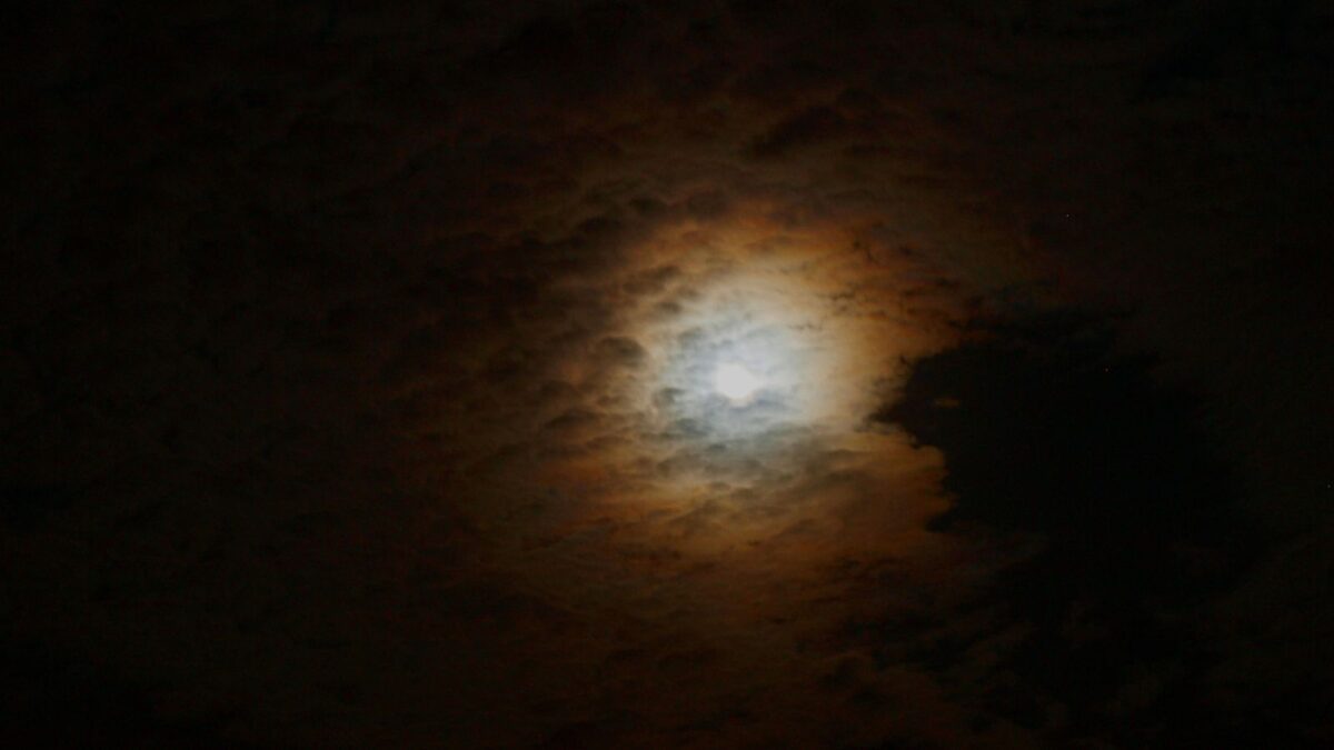 photo of the moon on a cloudy day