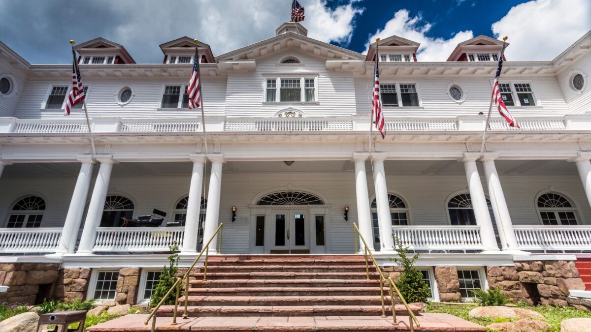photo looking up at a large white and red colonial hotel