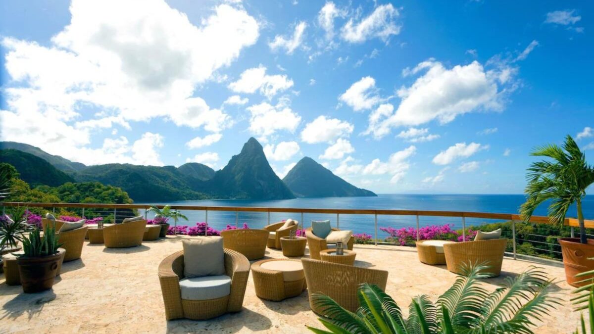 A seaside terrace with a view of mountain peaks.