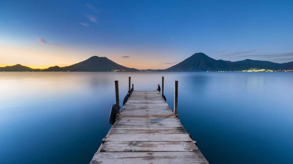 20 Breathtaking Lakes That Are True Natural Wonders! 7 peaceful lake with wooden dock extending out at sunrise