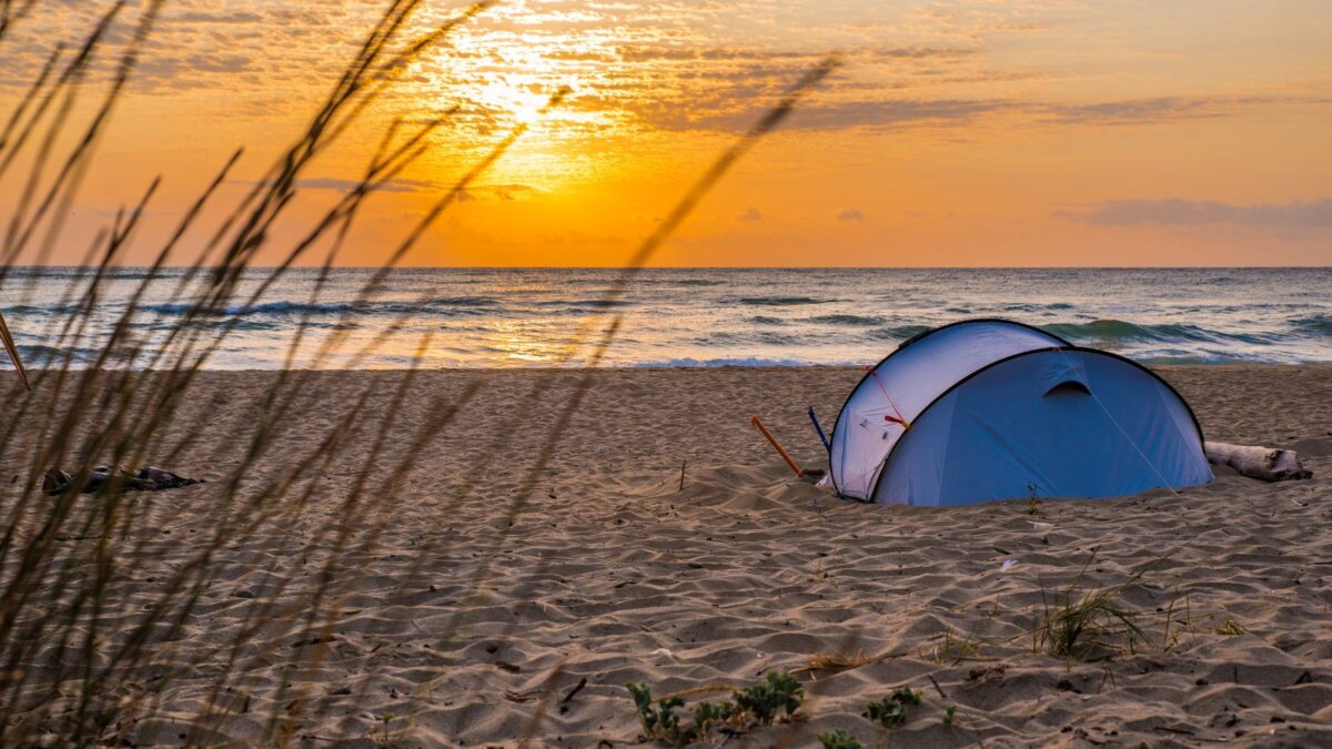 The Cheapest Way To Get To Dry Tortugas National Park 10
Tent on a beach at sunrise with ocean in the background and grass in the foreground.