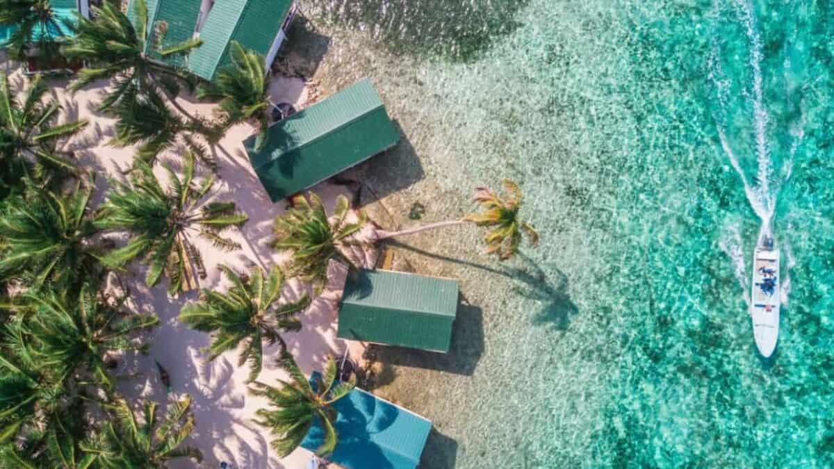 Discover the Central American Country You Need to Explore ASAP 3 Tobacco Caye aerial in Belize barrier reef with boat.