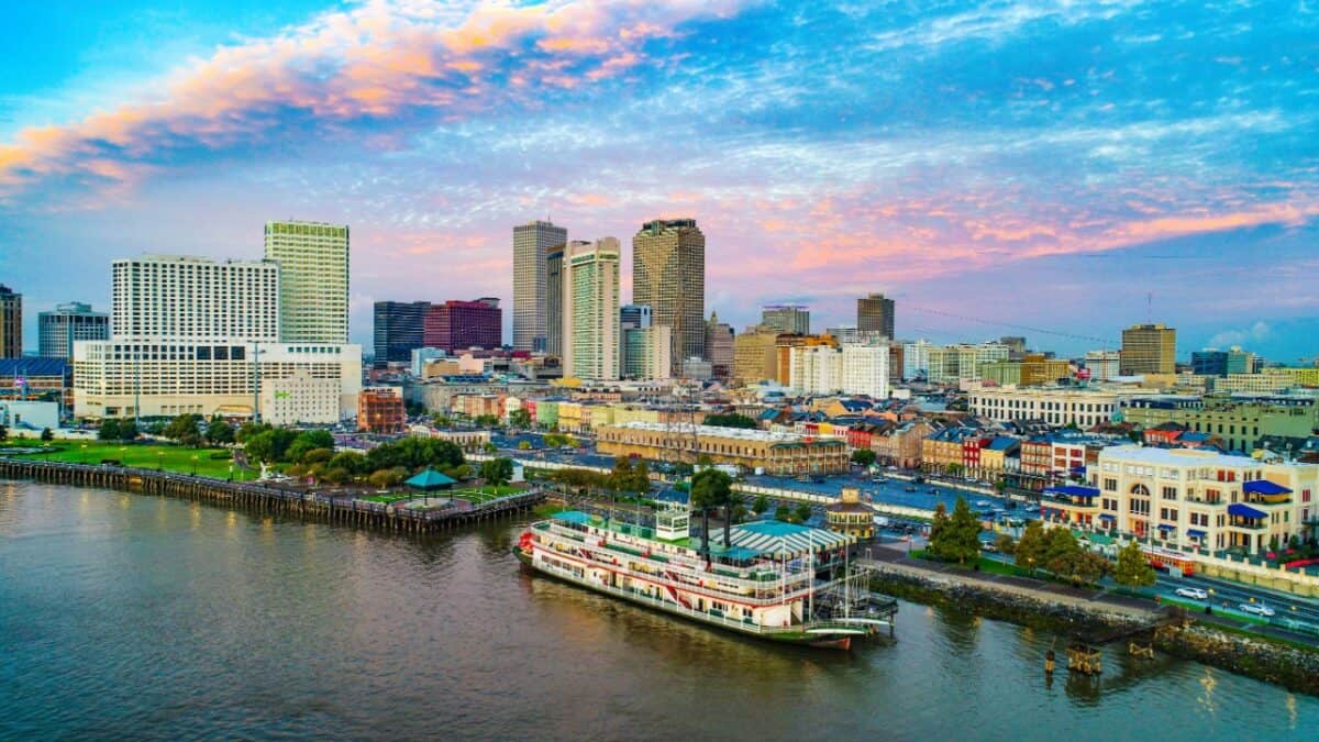 A vibrant skyline view at dusk with a paddle steamer on the riverfront, showcasing the dynamic blend of modern architecture and historical charm.