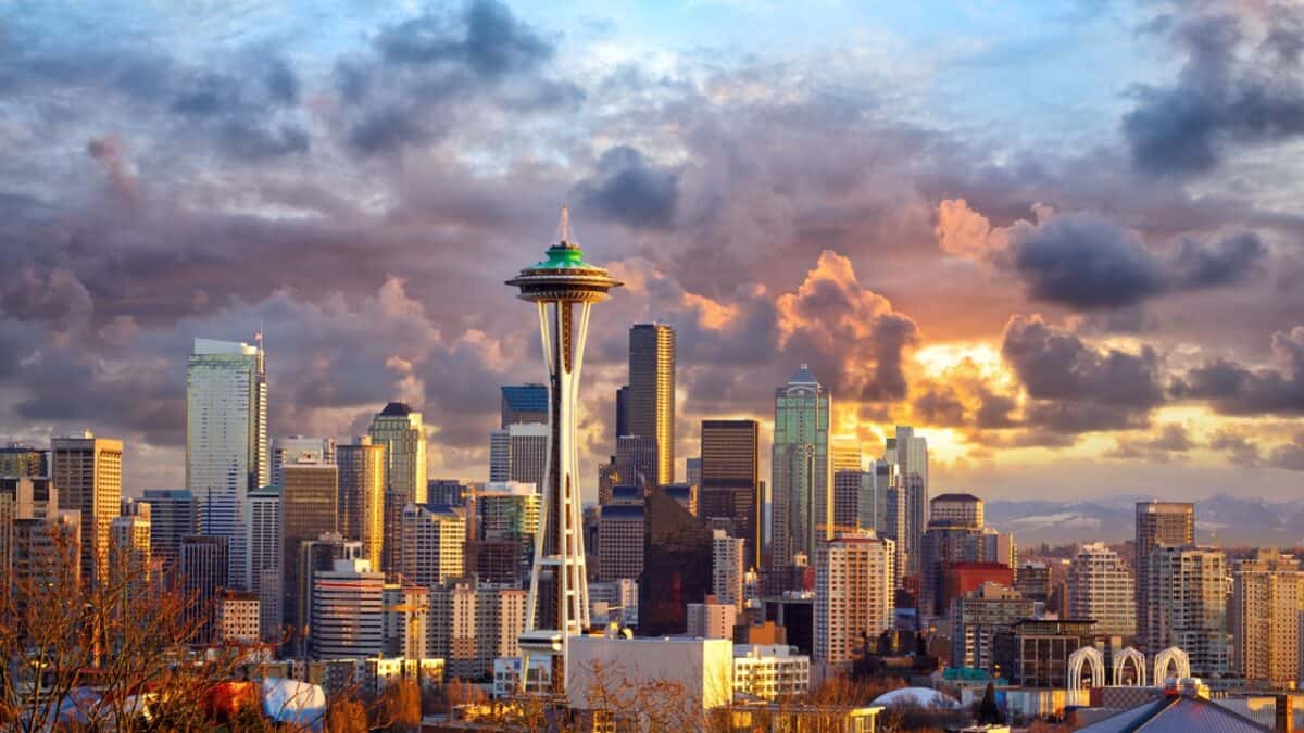 Seattle skyline at sunset with dramatic clouds, featuring the iconic space needle.