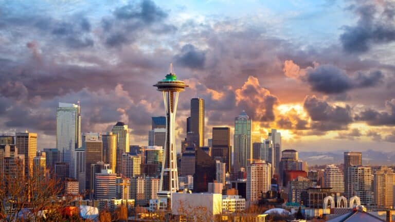 Seattle skyline at sunset with dramatic clouds, featuring the iconic space needle.