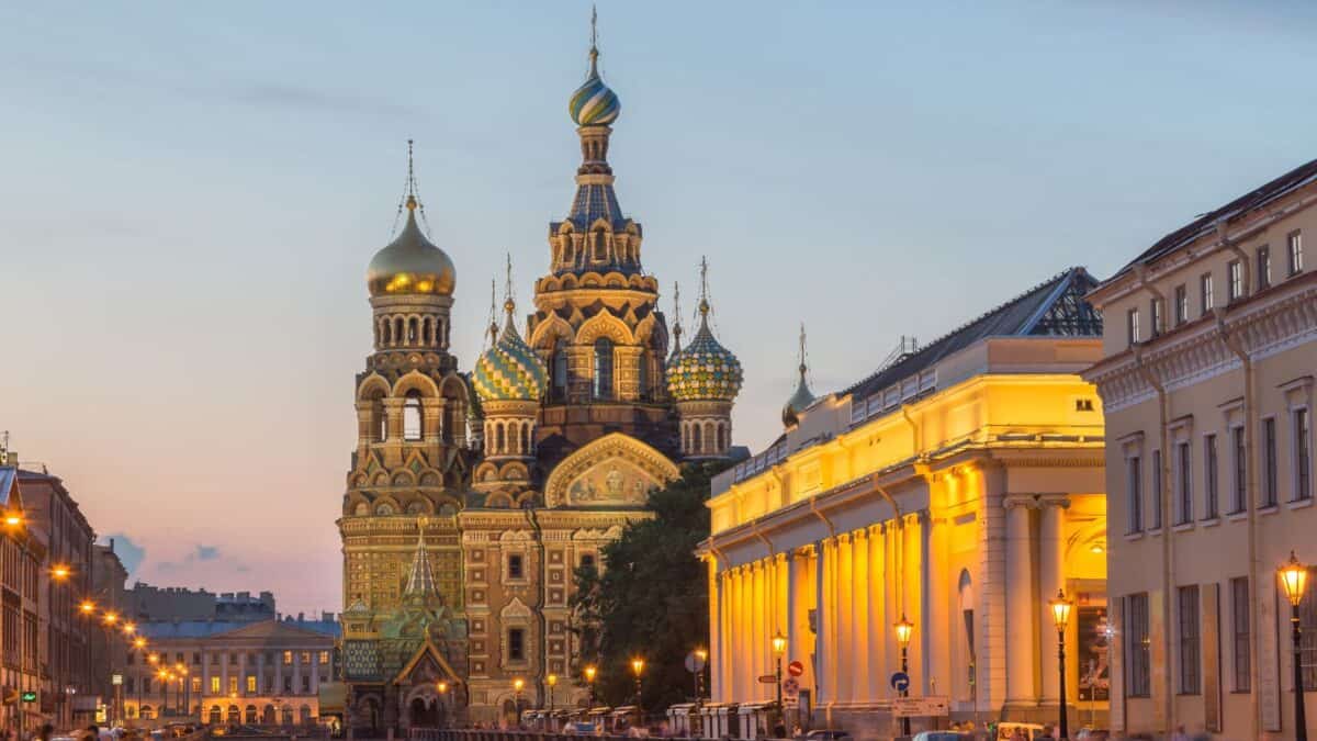 Twilight view of the Church of the Savior on Spilled Blood with its colorful onion domes, alongside a canal in Saint Petersburg, Russia.