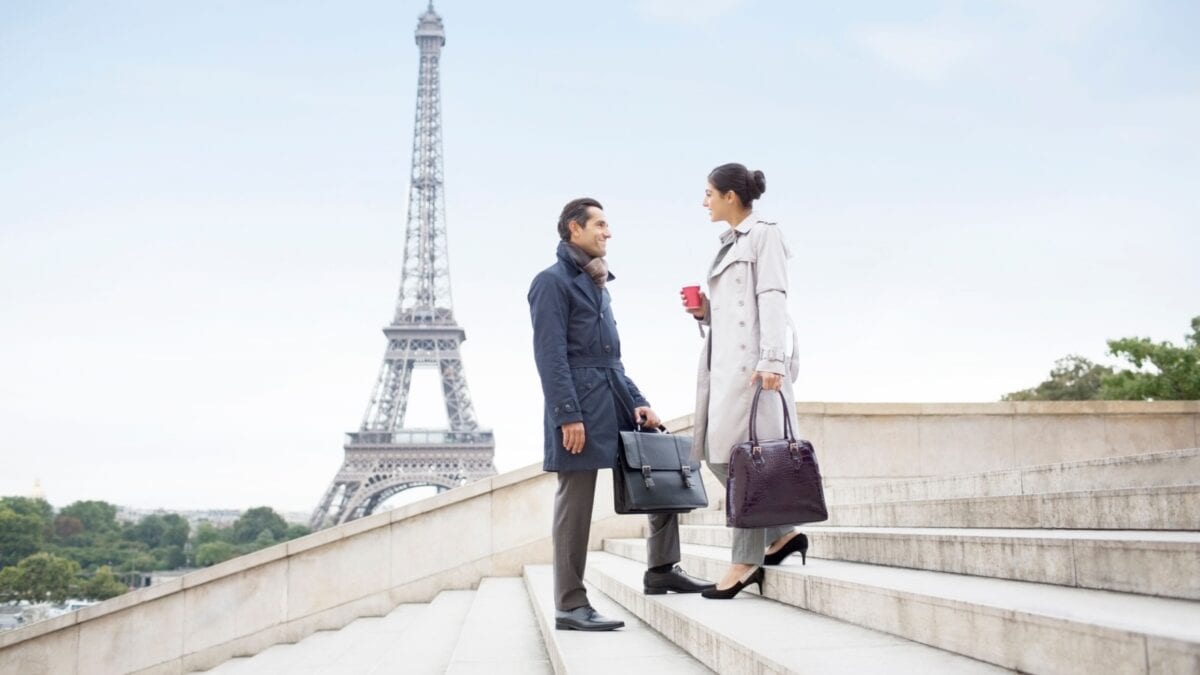 Woman and man crossing path on the stairway near the Eiffel Tower.