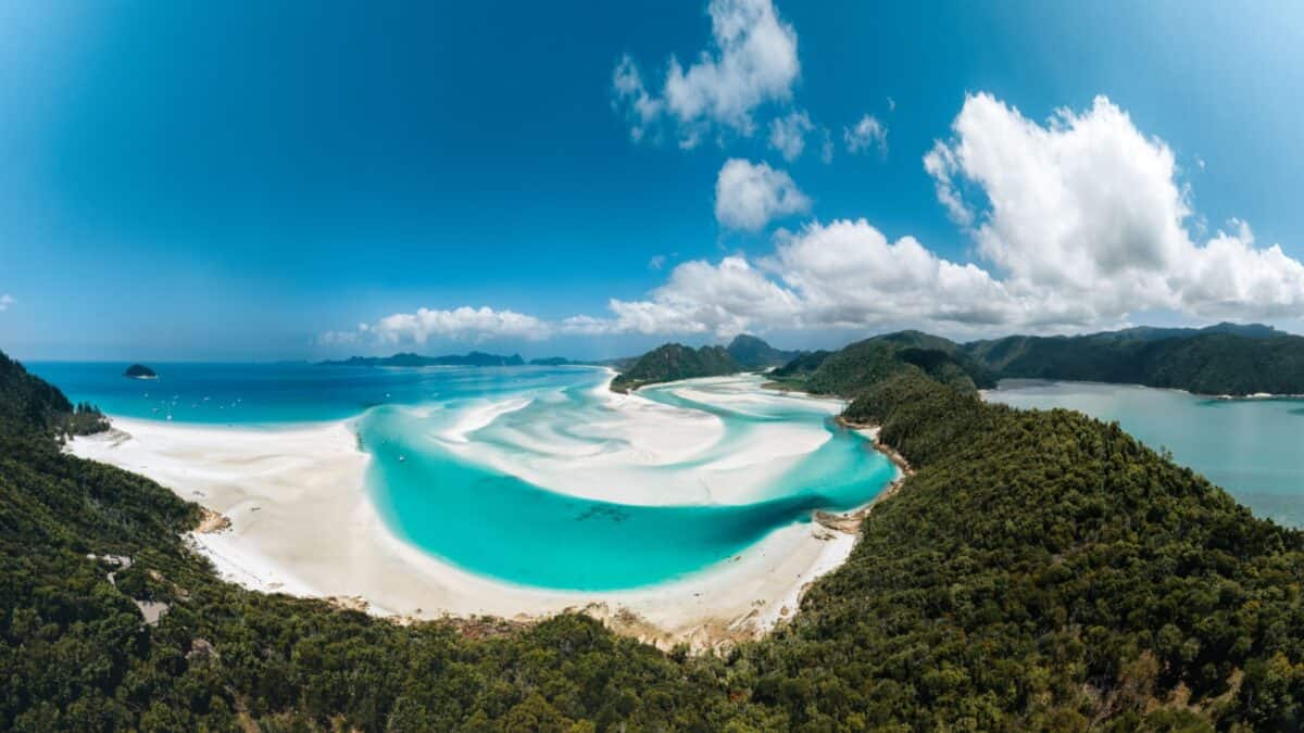 16 Survivor Locations that Would Actually Make Super Cool Vacation Destinations 4 White sand shore near the turquoise waters surrounded by trees on a beautiful sunny day.