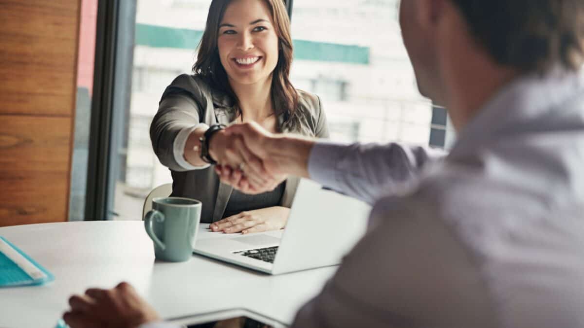 A woman shaking the hand of a man.