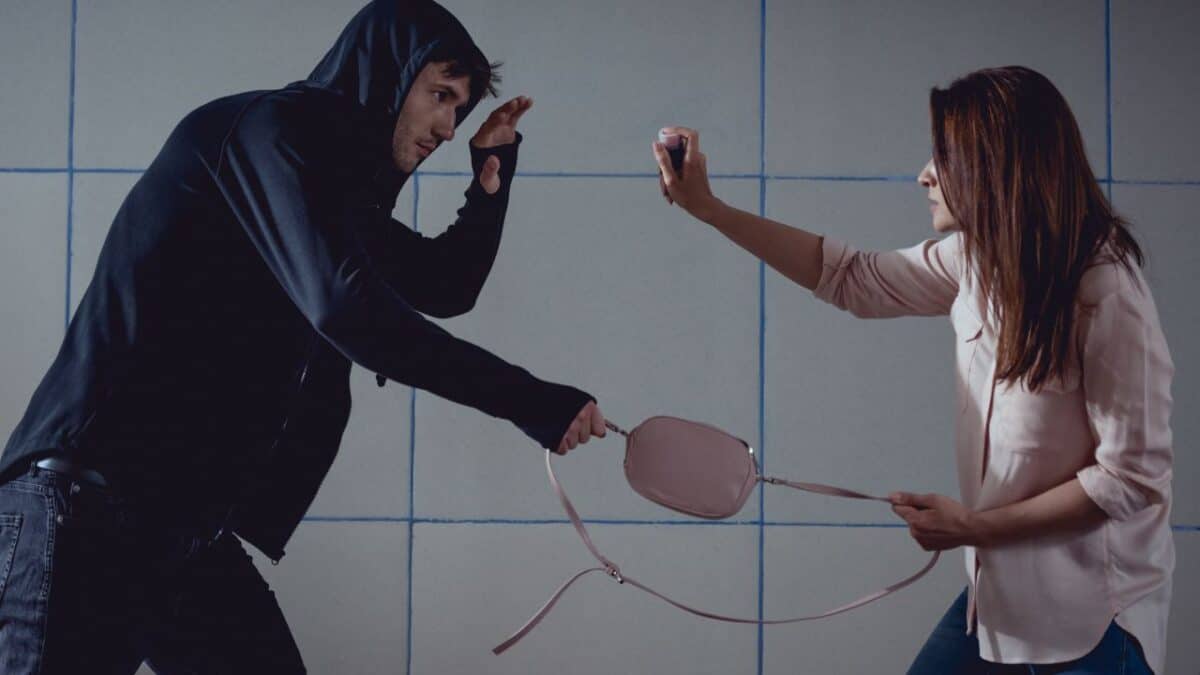 20 Ultimate No-Nos of Cruise Packing—Learn What's Banned 22 A woman using pepper spray for self-defense against a man attempting a snatch theft in a dimly lit urban environment.