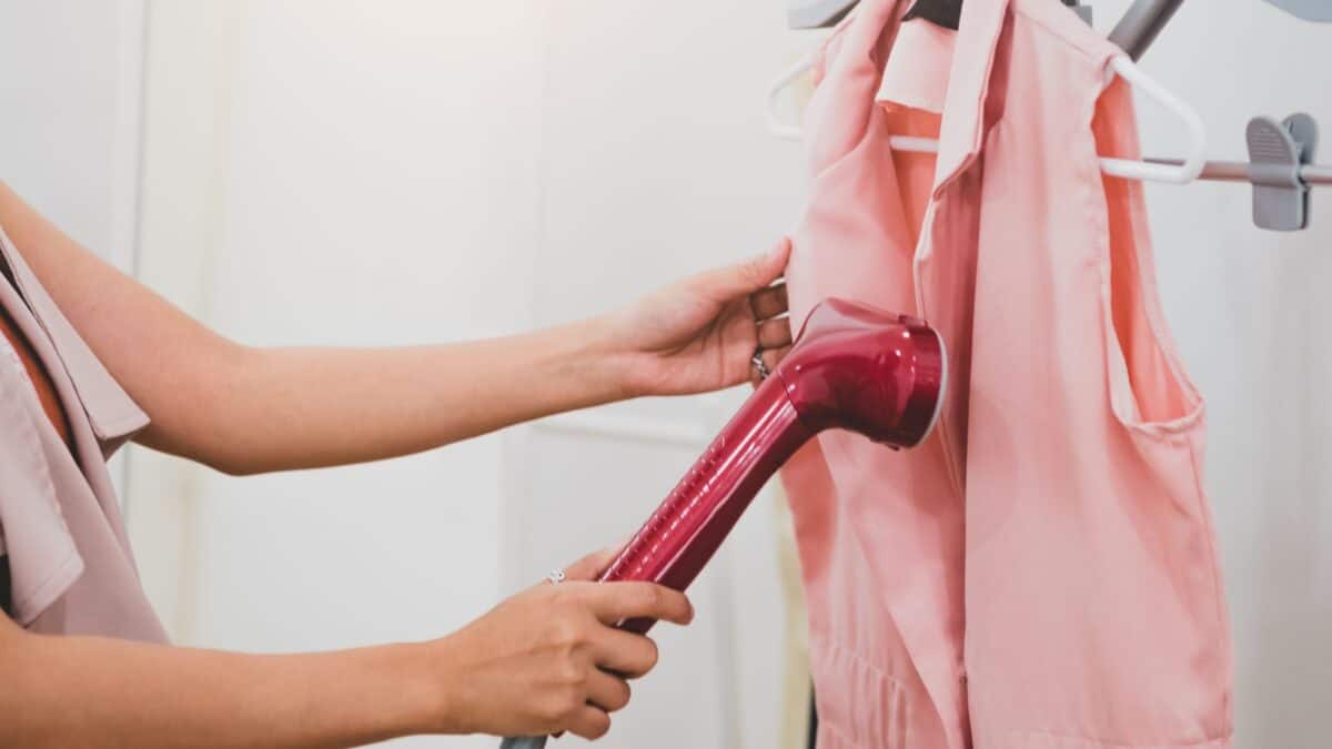 20 Ultimate No-Nos of Cruise Packing—Learn What's Banned 11 A woman steaming her pink top.