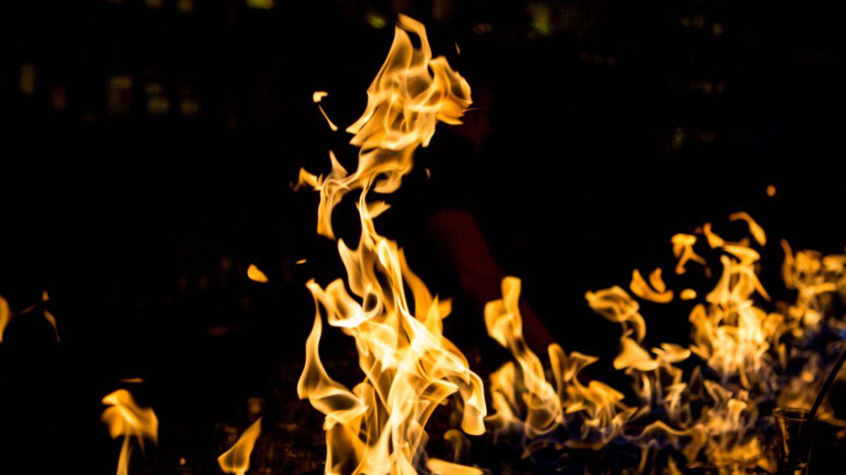 Bright orange flames rise against a dark background, creating a dramatic contrast. The fire appears to be burning intensely, illuminating the surrounding darkness with an eerie glow. It feels like one of those creepy things that could have really taken place in a sinister setting.