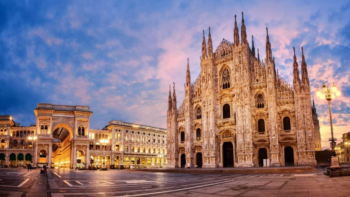 Panoramic view of Milan Cathedral and Galleria Vittorio Emanuele II at sunset, with an empty Piazza del Duomo in the foreground, evoking a sense of cities left behind as if frozen in time.