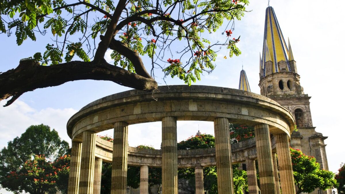15 Nostalgic Travel Destinations for Anyone Who Grew Up in the '70s 10 Circular stone monument with columns, flowering tree, and pointed church towers in the background.